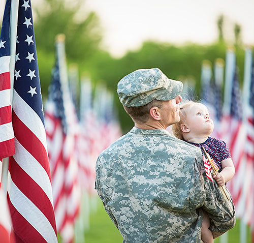 military man, child and U.S. flags